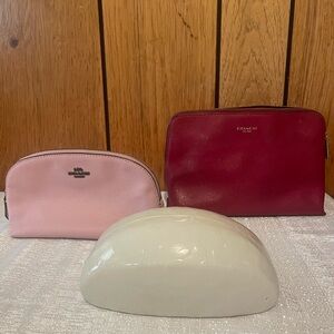 Red and blush pink Coach cosmetics pouches plus a white glasses case